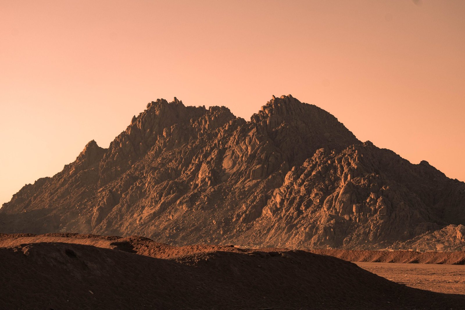 Dramatic sunset view of rugged mountains in Sharm El-Sheikh, Egypt, with warm hues.