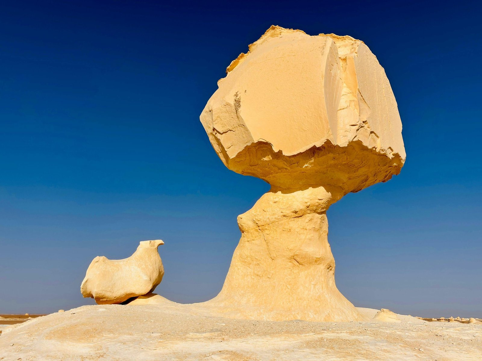 Sculptural rock formations under a clear blue sky in the White Desert, Egypt.