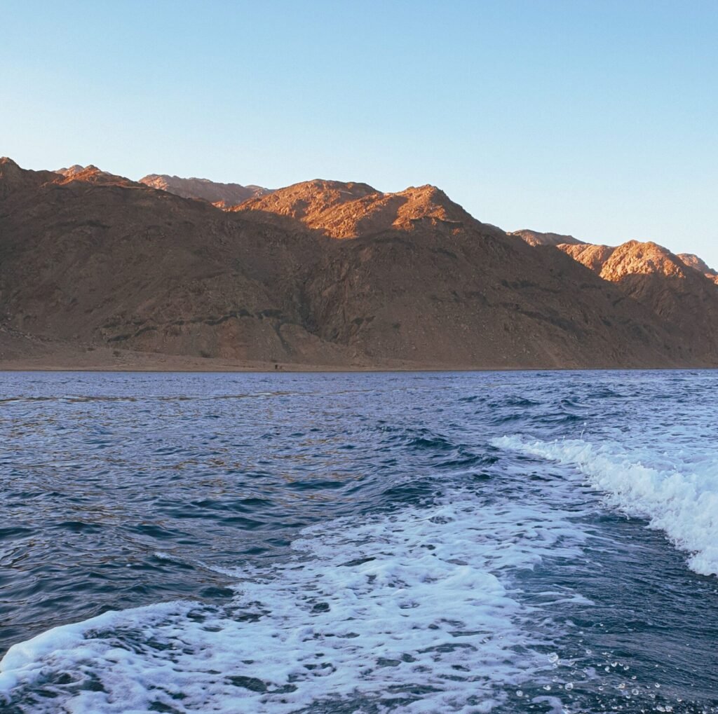 Scenic view of the Red Sea waves with mountains in Dahab, Egypt.