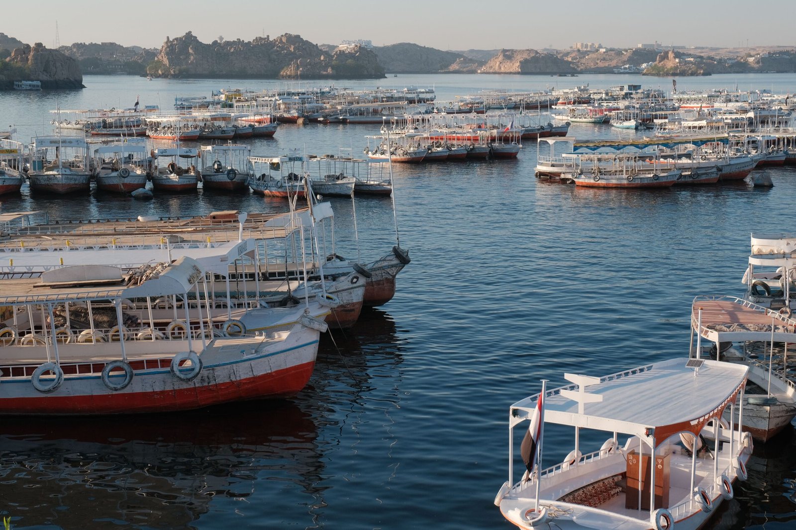 Many traditional boats moored at sunrise in a peaceful harbor, showcasing a tranquil scene.
