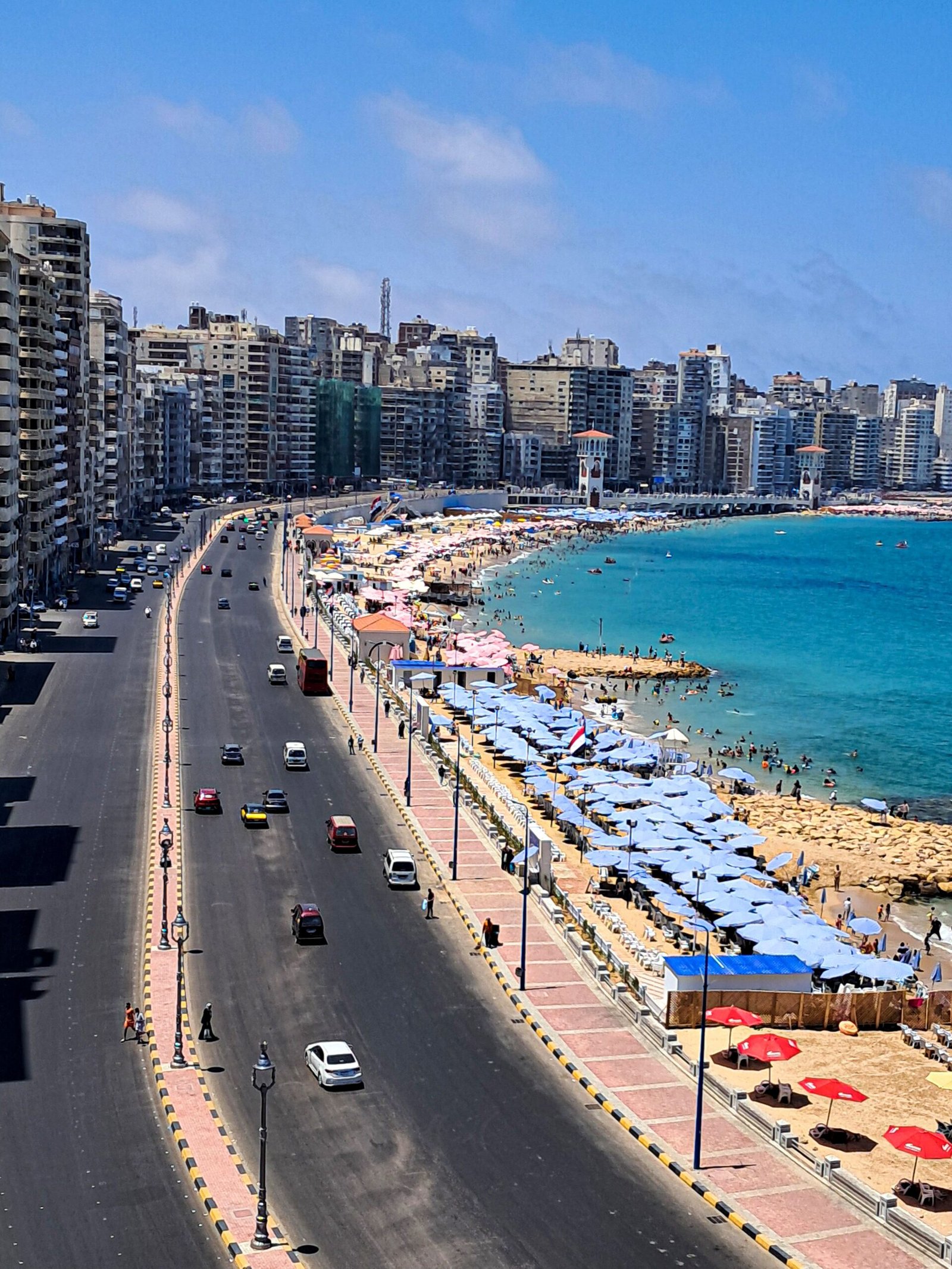 Aerial view of Alexandria's bustling coastline, capturing a vibrant beach and cityscape.